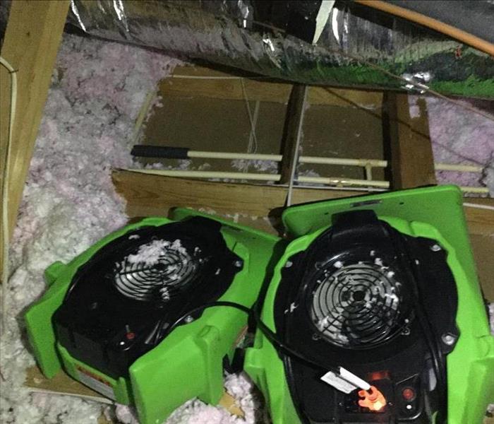 green SERVPRO fans in attic, 2x4's with insulation and wires