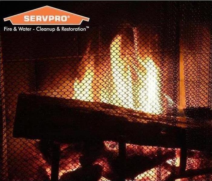 fireplace with logs and flames, servpro logo in top left corner