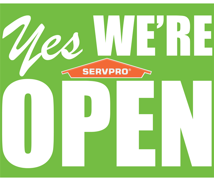 Green background with "yes we are open" and orange SERVPRO house